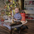 Load image into Gallery viewer, Doll in a checkered outfit sitting at a table with a Christmas tree in the background