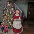 Load image into Gallery viewer, Mrs. Claus doll holding a plate, with a Christmas tree and teddy bears in the background.