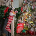 Load image into Gallery viewer, Decorative Christmas stocking with candy canes, surrounded by festive decorations.