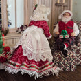 Load image into Gallery viewer, Mrs. Claus miniature doll with Santa Claus sitting on a patterned chair.