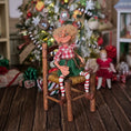 Load image into Gallery viewer, Christmas elf with glasses by artist Cynthia Baron, in chair
