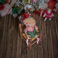 Load image into Gallery viewer, Christmas elf with glasses by artist Cynthia Baron, in chair