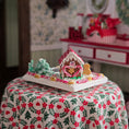 Load image into Gallery viewer, Decorative gingerbread house on a floral tablecloth with a festive background