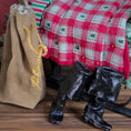 Load image into Gallery viewer, Black boots with an empty toy bag of Santa's