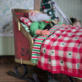 Load image into Gallery viewer, Santa Claus in a sleigh bed with a checkered blanket, Christmas tree in the background