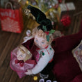 Load image into Gallery viewer, Elf boy doll carrying jack-in-the-box toy with a festive background