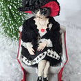 Load image into Gallery viewer, “Winter Lady” Doll in a black outfit with white patterns, sitting in a sleigh with a snowy background