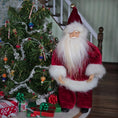 Load image into Gallery viewer, Santa Claus dollhouse doll in front of a decorated Christmas tree with presents.