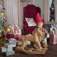 Load image into Gallery viewer, Clay elf character on a rocking horse with Christmas decorations in the background