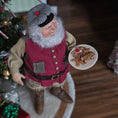 Load image into Gallery viewer, Santa Claus doll holding a plate of cookies in front of a Christmas tree.
