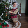 Load image into Gallery viewer, Old Christmas Elf doll with a beard and plaid hat standing next to a decorated Christmas tree.