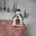 Load image into Gallery viewer, Small decorative church model held in a hand with a snowy background