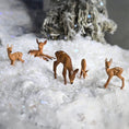 Load image into Gallery viewer, Deer figurines on a snowy surface with a blurred tree in the background