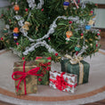 Load image into Gallery viewer, Decorative Christmas scene with small gift boxes and a tree in the background.