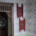 Load image into Gallery viewer, Red wall shelves with decorative painted accents against a floral wallpapered wall.