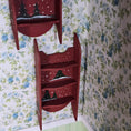 Load image into Gallery viewer, Red bookshelf with decorative design against floral wallpaper