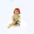 Load image into Gallery viewer, Catherine Muniere doll with red hair and a yellow sweater holding a toy against a white background