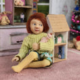 Load image into Gallery viewer, Catherine Muniere doll with red hair and sweater in a playroom setting.