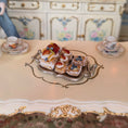 Load image into Gallery viewer, Delicate miniature pastries with berries on a silver tray on an ornate table.
