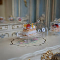 Load image into Gallery viewer, Small cake with fruit on a decorative table in an elegant room.