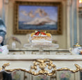 Load image into Gallery viewer, Delicate dessert on a clear. footed stand with a decorative interior setting