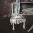 Load image into Gallery viewer, Vintage-style chair with floral patterns and lace skirt in a softly blurred background