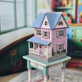 Load image into Gallery viewer, Laura Eppich 1:144 Lavender & Blue Three-Story Victorian Dollhouse on Blue Table