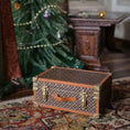 Load image into Gallery viewer, Decorative chest on a patterned rug with a Christmas tree in the background