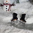 Load image into Gallery viewer, Dollhouse miniature ice skates on a snowy surface with a snowman in the background.
