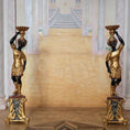 Load image into Gallery viewer, Pair of ornate gold and black statues holding bowls in a room with marble walls and floor.