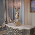 Load image into Gallery viewer, Decorative gold clock on a marble surface with a blurred background