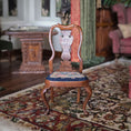 Load image into Gallery viewer, Wooden chair with a patterned needlepoint seat on a decorative rug in a room with furniture and decor.