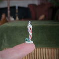 Load image into Gallery viewer, Small figurine held between fingers with a blurred background