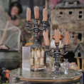 Load image into Gallery viewer, Decorative candelabra with candles on a clear stand against a blurred Halloween-themed background.