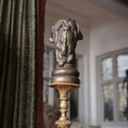 Load image into Gallery viewer, Decorative bronze sculpture bust with a dog's head design against a blurred indoor background.