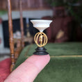 Load image into Gallery viewer, Decorative sculpture with a metal male figure on a black base held on a finger with a blurred indoor background