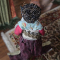Load image into Gallery viewer, Decorative figure with a textured headpiece and colorful clothing in a home setting