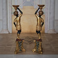 Load image into Gallery viewer, Pair of ornate pedestals with gold and black finish in a classical setting.