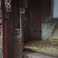 Load image into Gallery viewer, Decorative wooden seat with ornate cushions in a traditional opium wedding bed setting