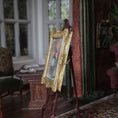 Load image into Gallery viewer, Decorative painting on a gold easel in an elegant room with furniture and a window.