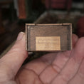 Load image into Gallery viewer, Wooden underside of clock with a signed G. Wonnacott signature, held in a hand against a blurred background