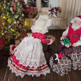 Load image into Gallery viewer, Decorative Christmas scene with a Mr. and Mrs. Claus miniature dolls in front of a decorated tree.