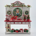 Load image into Gallery viewer, Decorative Christmas-themed cabinet with wreaths, nutcrackers, and gift boxes on a white background