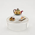 Load image into Gallery viewer, Decorative miniature tea set with a teapot, cake, and pastries on a clear stand against a white background.