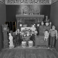 Load image into Gallery viewer, Black and white photo of a detailed dollhouse interior with furniture and decorative items.