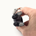 Load image into Gallery viewer, Hand holding the signed underside of a OOAK clay Asian character doll by Sharon Cariola, 2018