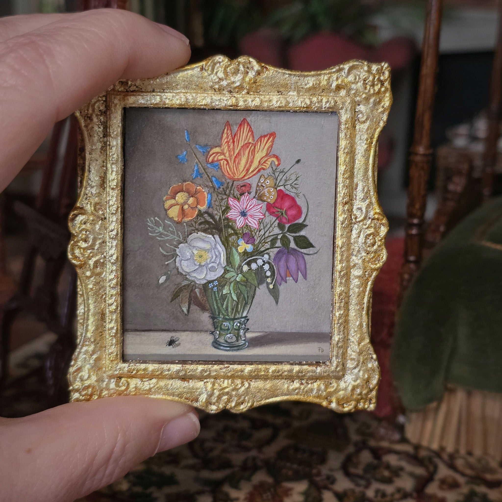 Decorative dollhouse gold frame with a floral oil painting on a fabric background by Fatima Dona