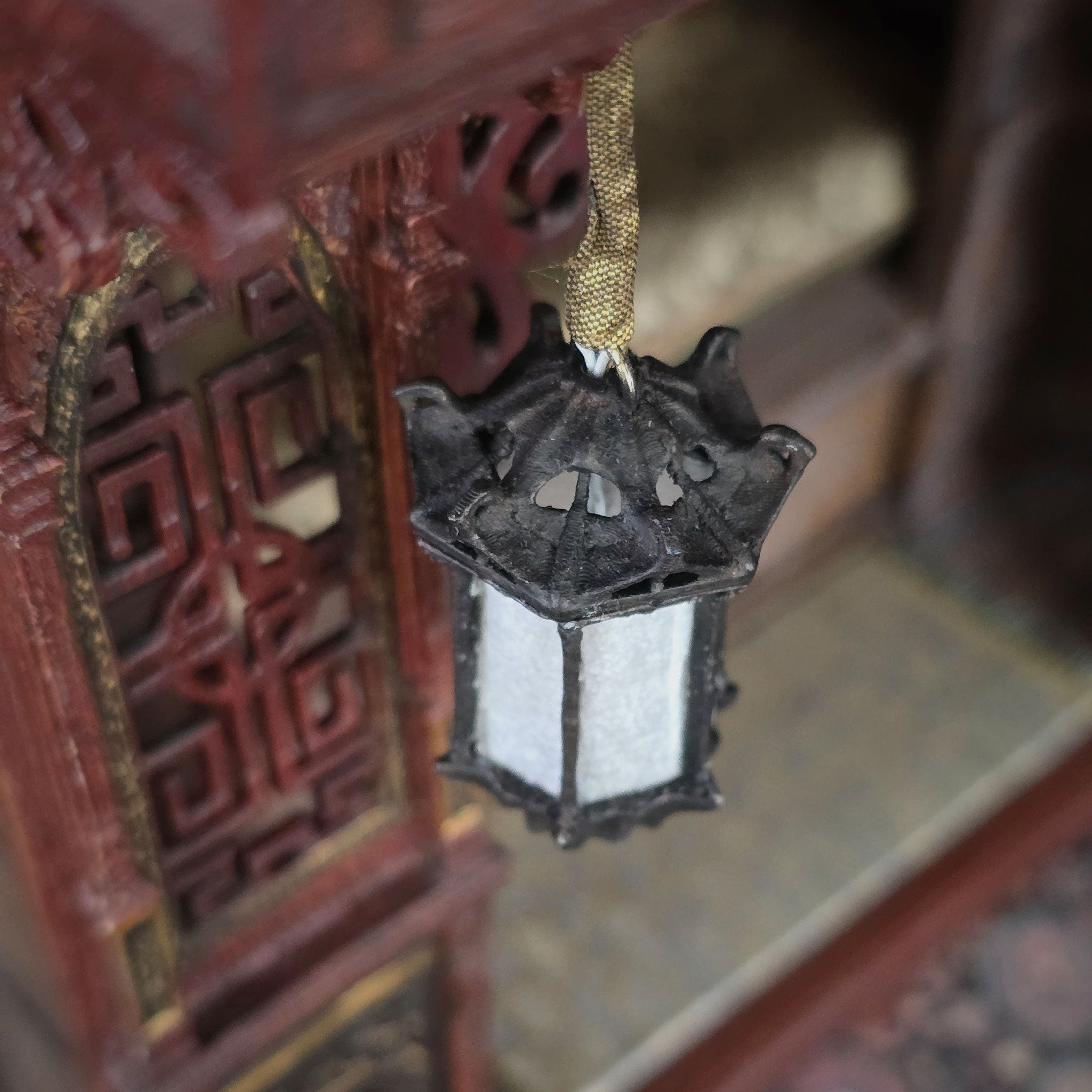 Decorative lantern hanging from a traditional wooden structure