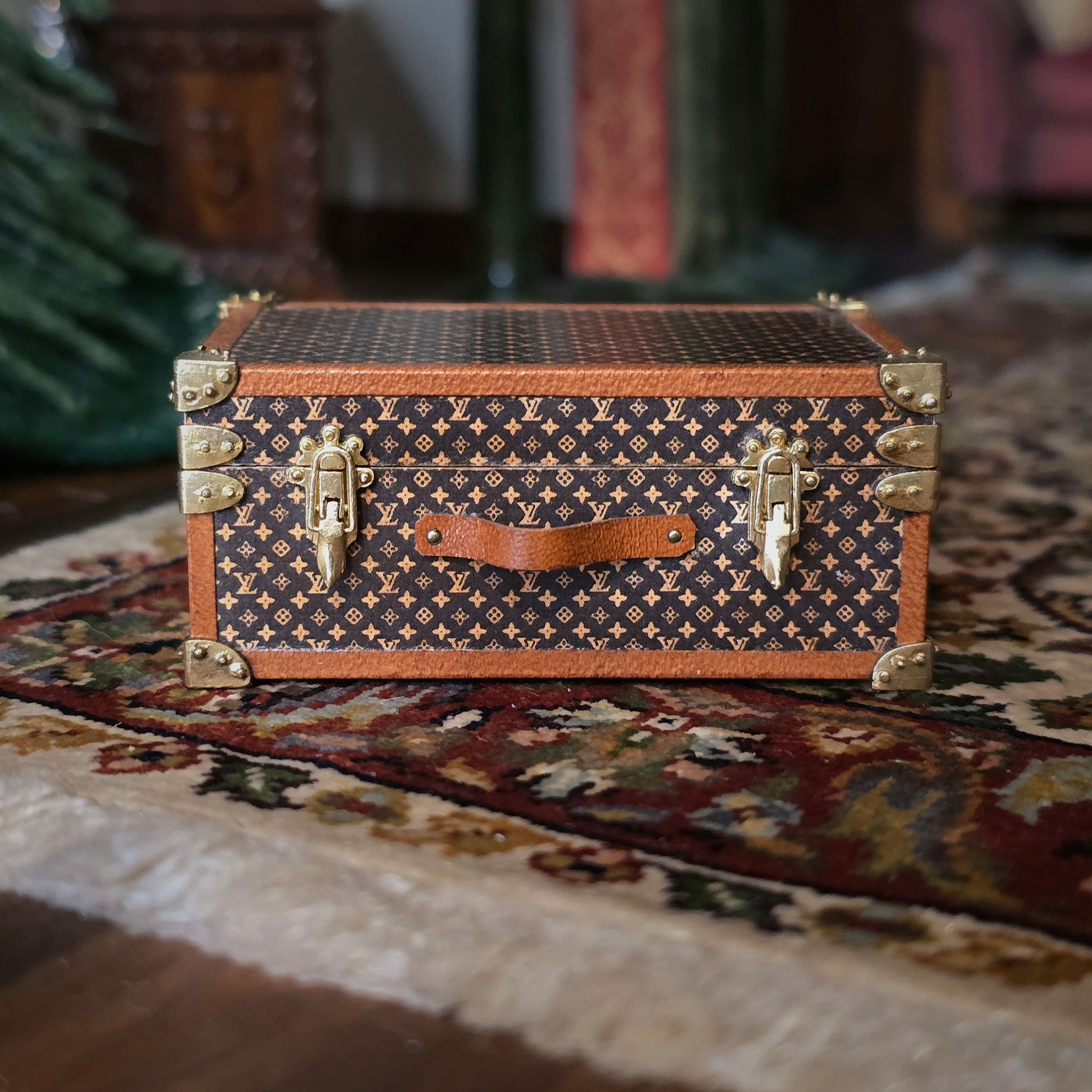Vintage-style suitcase or chest with patterned design on a textured surface