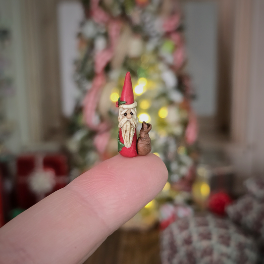 Miniature Pencil Santa Figurine – Folk Art Clay, resting on a finger